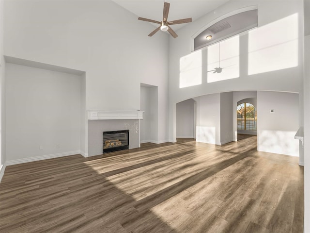 unfurnished living room featuring dark hardwood / wood-style flooring and ceiling fan