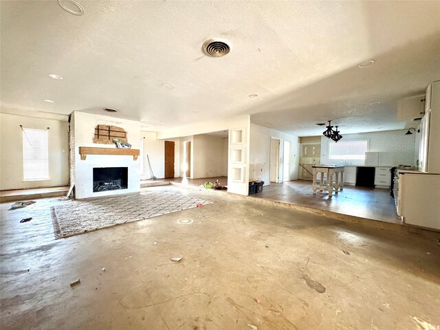 2304 Royal Acres Dr, Denton, TX 76209 - unfurnished living room featuring concrete flooring, a textured ceiling, and a fireplace