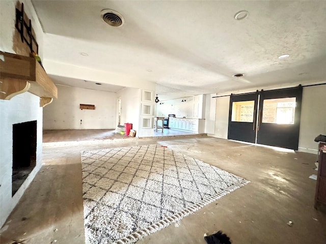 2304 Royal Acres Dr, Denton, TX 76209 - unfurnished living room featuring a barn door and concrete floors