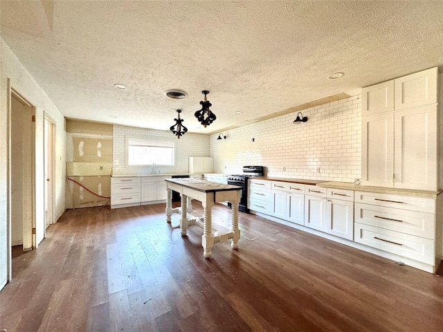 2304 Royal Acres Dr, Denton, TX 76209 - kitchen featuring tasteful backsplash, sink, white cabinets, dark hardwood / wood-style flooring, and stainless steel gas range