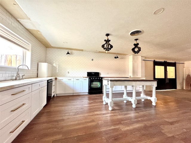 2304 Royal Acres Dr, Denton, TX 76209 - kitchen featuring sink, white cabinets, hardwood / wood-style flooring, black appliances, and a barn door