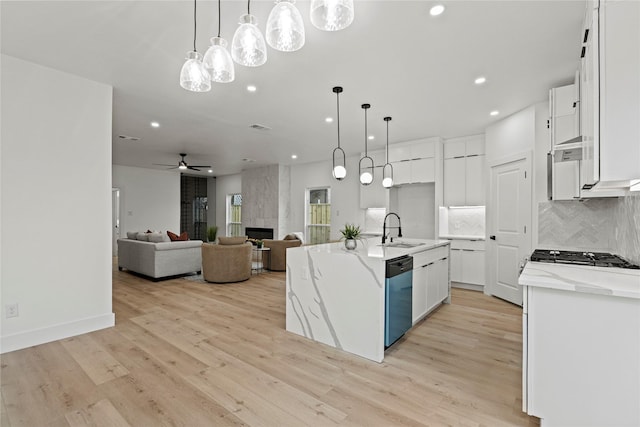 kitchen with decorative light fixtures, white cabinetry, an island with sink, sink, and stainless steel appliances