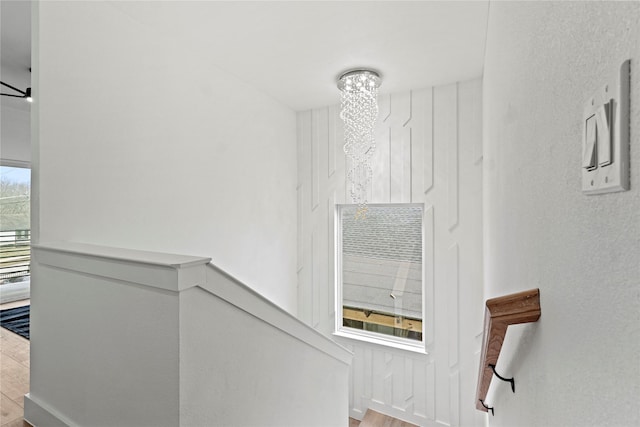 staircase with a notable chandelier and hardwood / wood-style floors