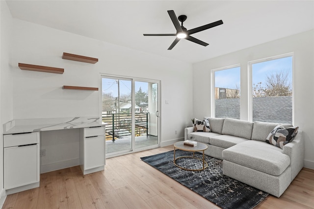 living room featuring ceiling fan and light hardwood / wood-style floors