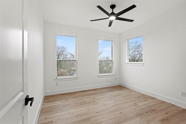 spare room featuring ceiling fan, light hardwood / wood-style flooring, and a healthy amount of sunlight