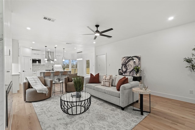 living room featuring light hardwood / wood-style floors and ceiling fan