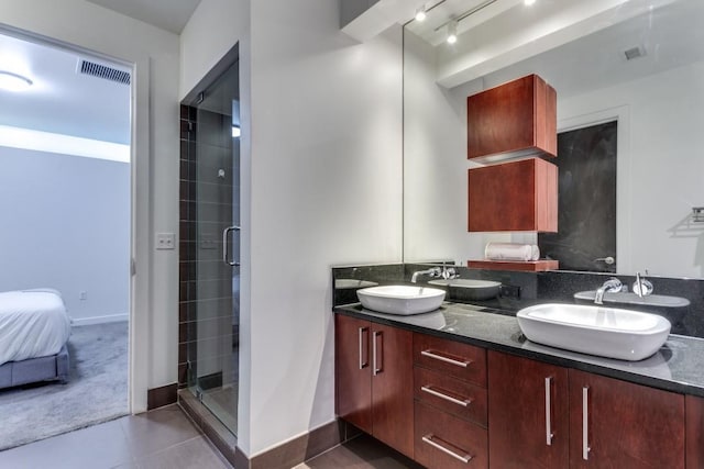 bathroom featuring tile patterned flooring, vanity, track lighting, and a shower with shower door