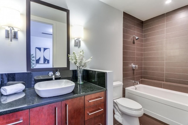 full bathroom featuring vanity, toilet, and tiled shower / bath combo