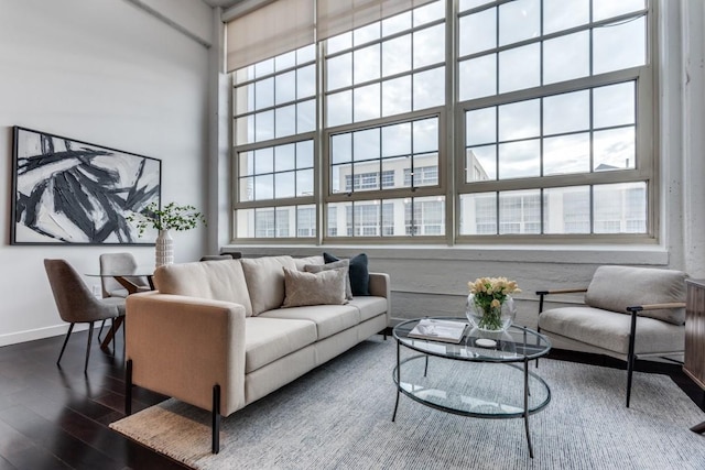 living room featuring plenty of natural light, dark hardwood / wood-style floors, and a high ceiling