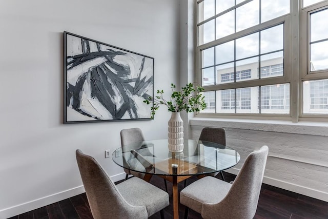 dining room featuring plenty of natural light, dark hardwood / wood-style floors, and a towering ceiling