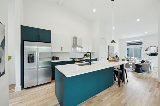 2138 Lovedale Ave Unit 105, Dallas, TX 75235 - kitchen with light countertops, a sink, wall chimney exhaust hood, appliances with stainless steel finishes, and high vaulted ceiling