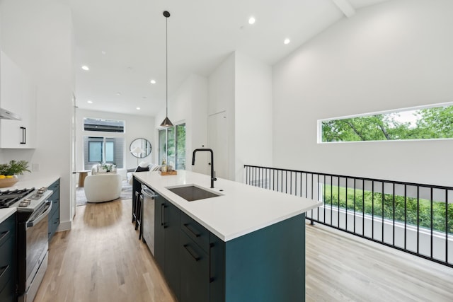 2138 Lovedale Ave Unit 105, Dallas, TX 75235 - kitchen featuring light wood finished floors, stainless steel appliances, light countertops, a sink, and high vaulted ceiling