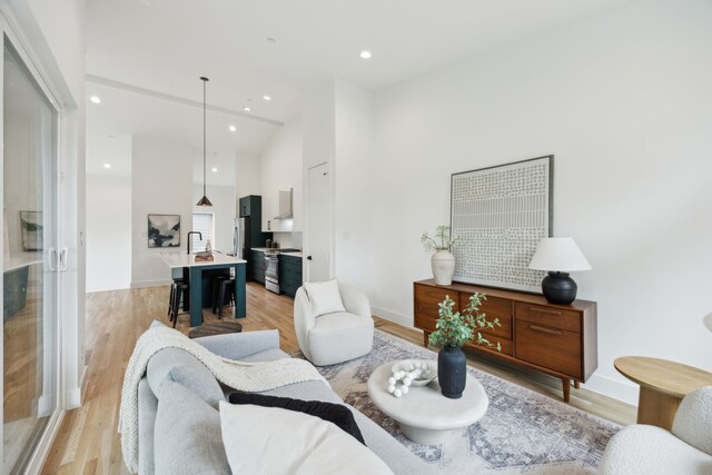 2138 Lovedale Ave Unit 105, Dallas, TX 75235 - living room with light wood finished floors, baseboards, recessed lighting, and high vaulted ceiling