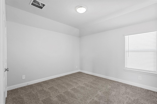 spare room featuring lofted ceiling and carpet floors