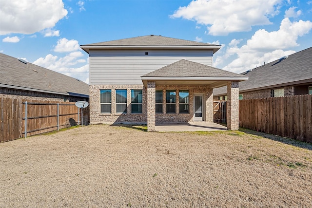 back of house featuring a lawn and a patio area