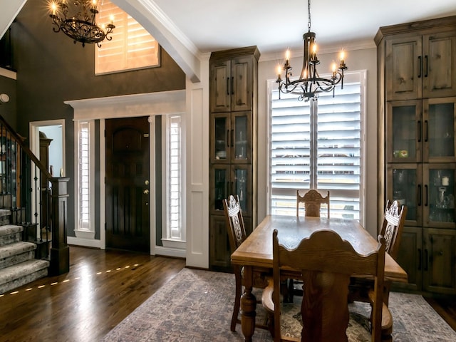 dining space featuring crown molding, dark hardwood / wood-style floors, and a chandelier