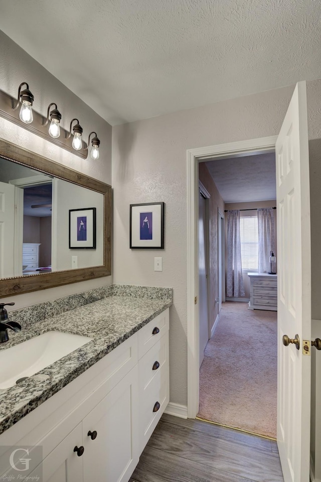 bathroom with vanity, wood-type flooring, and a textured ceiling