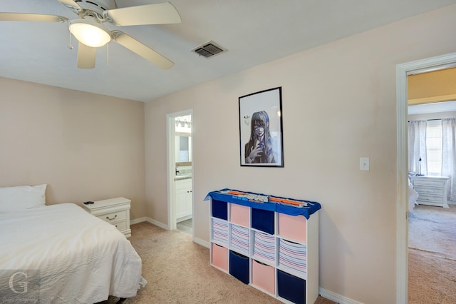 bedroom featuring light carpet, connected bathroom, and ceiling fan