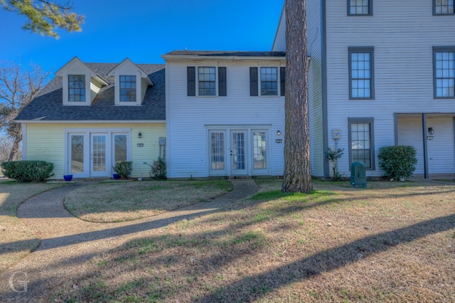 view of front facade with a front lawn and french doors