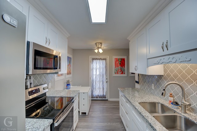 kitchen featuring sink, light stone countertops, white cabinets, and appliances with stainless steel finishes