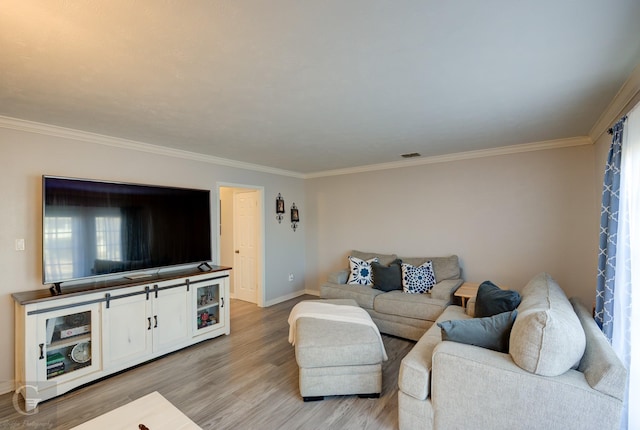 living room featuring crown molding, hardwood / wood-style flooring, and a healthy amount of sunlight