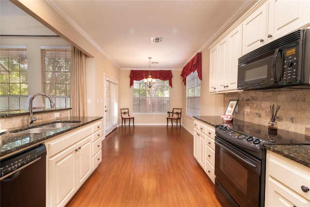 kitchen featuring sink, light wood-type flooring, ornamental molding, pendant lighting, and black appliances