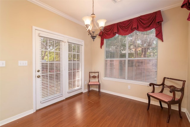 living area featuring dark hardwood / wood-style flooring, crown molding, and an inviting chandelier