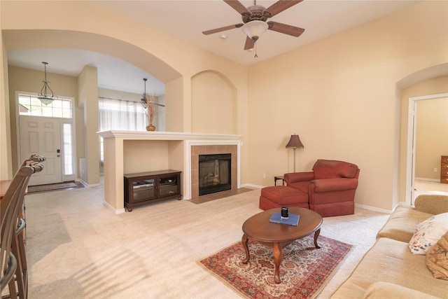 living room featuring light carpet, a fireplace, and ceiling fan