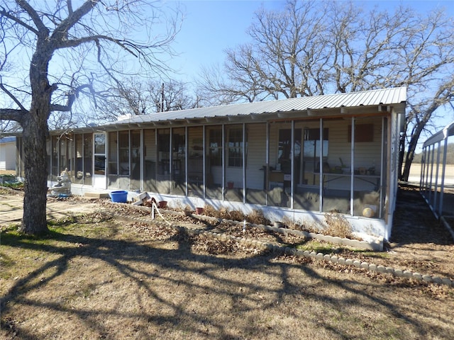 rear view of house featuring a sunroom