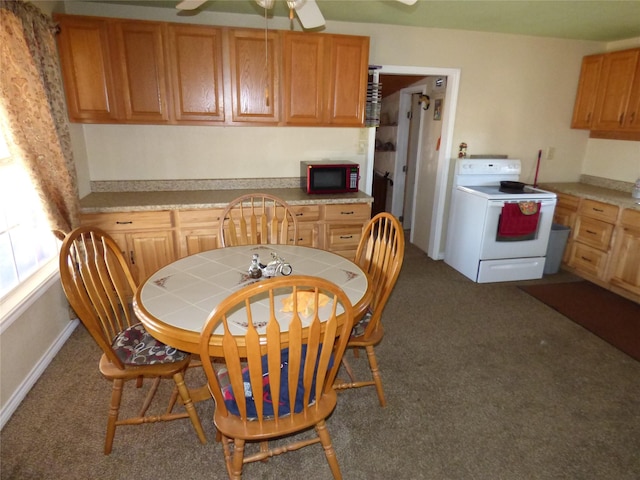 dining room with dark colored carpet and a ceiling fan