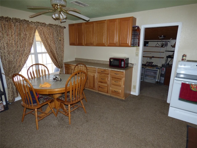 dining room featuring a ceiling fan, visible vents, and dark carpet