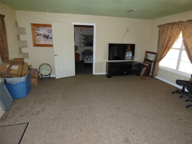 living area with carpet flooring, visible vents, and baseboards