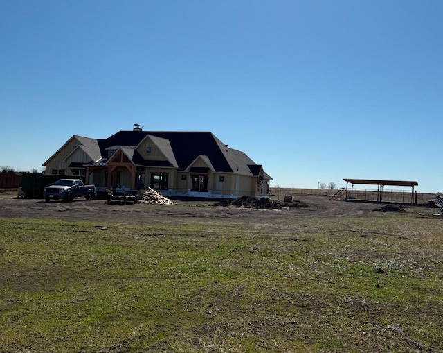 rear view of property with a carport and a lawn