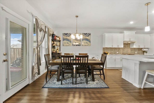 dining room featuring dark wood-type flooring, sink, and an inviting chandelier