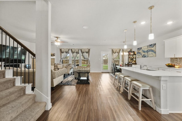 living room with sink, dark hardwood / wood-style floors, and ceiling fan