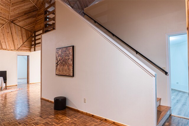 living area with dark parquet floors, a wall mounted air conditioner, and high vaulted ceiling