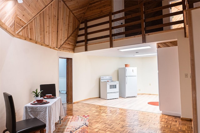 kitchen with light parquet floors, high vaulted ceiling, and white appliances