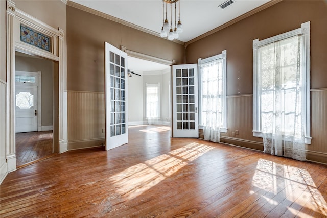 spare room with hardwood / wood-style floors, ornamental molding, and french doors