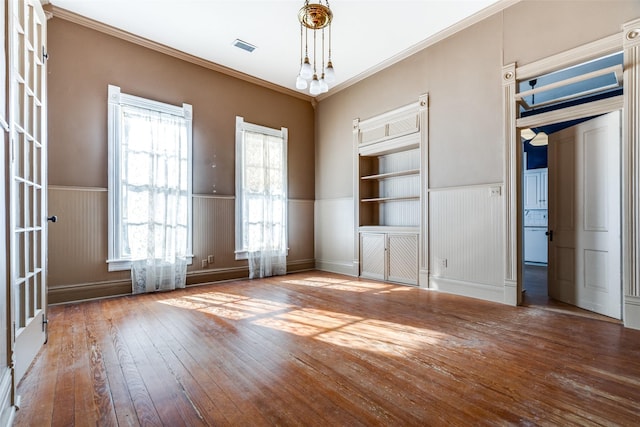 unfurnished room with ornamental molding and hardwood / wood-style floors