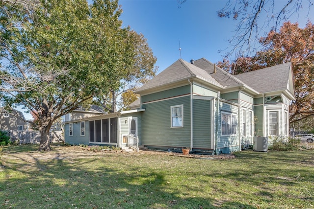 rear view of property with a lawn and central air condition unit