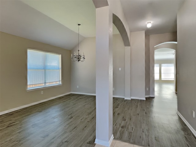 interior space with hardwood / wood-style flooring, lofted ceiling, and a chandelier