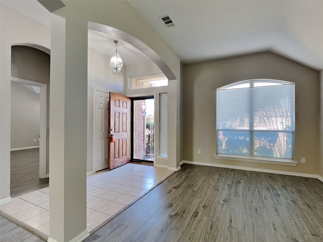 entrance foyer with lofted ceiling, light hardwood / wood-style flooring, and a wealth of natural light