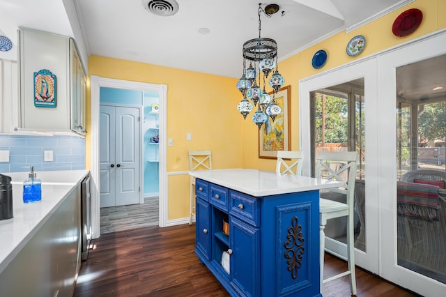 kitchen featuring blue cabinets, a kitchen island, dark hardwood / wood-style flooring, and decorative light fixtures