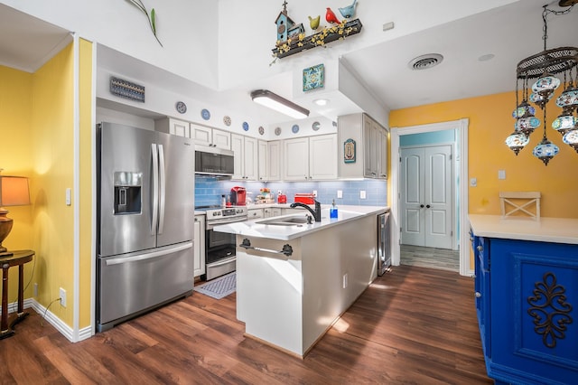 kitchen featuring dark hardwood / wood-style floors, sink, white cabinets, hanging light fixtures, and stainless steel appliances