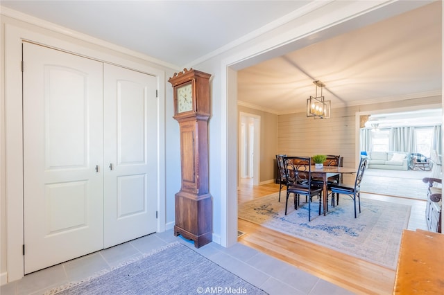 tiled dining room with an inviting chandelier and ornamental molding