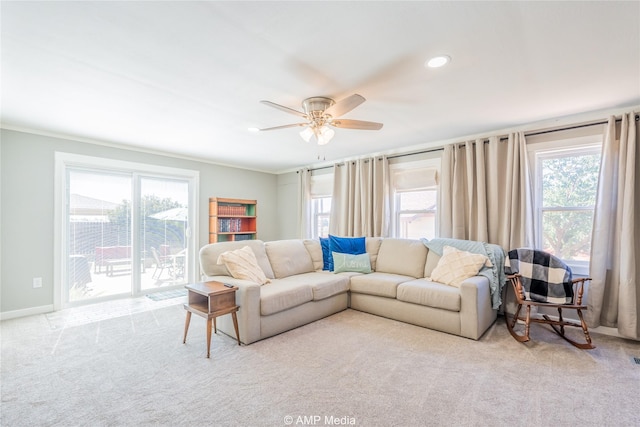 living room featuring ornamental molding, plenty of natural light, and light colored carpet