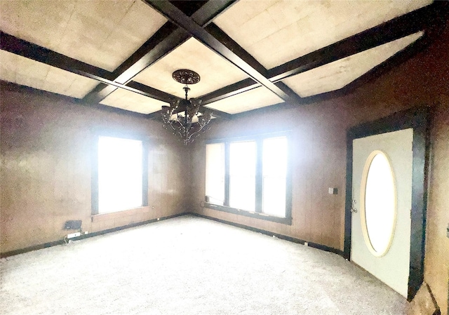 carpeted entryway with coffered ceiling, plenty of natural light, and beamed ceiling