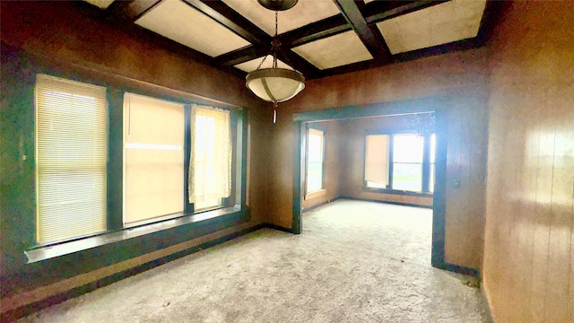 carpeted empty room featuring beamed ceiling and coffered ceiling