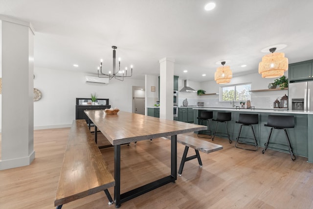 dining area featuring a notable chandelier, a wall mounted AC, and light wood-type flooring