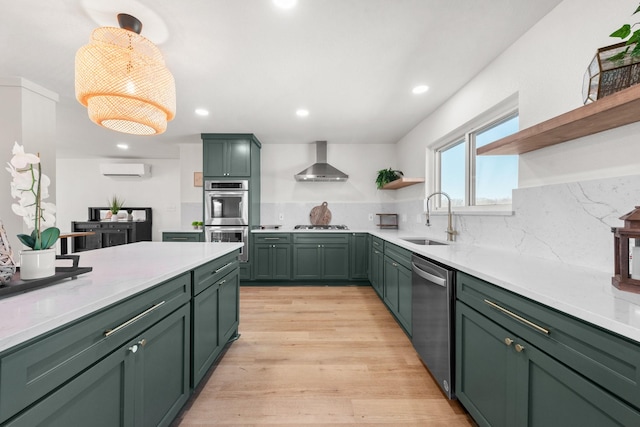 kitchen featuring sink, green cabinets, stainless steel appliances, an AC wall unit, and wall chimney exhaust hood